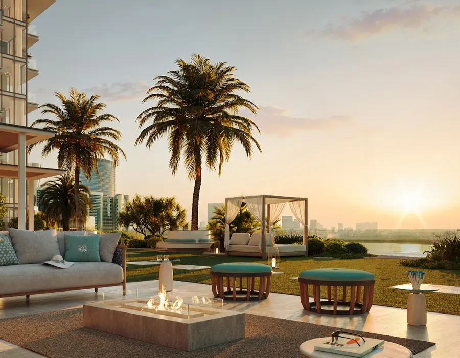 Beach Club terrace with a fire table, cabana and palms at sunset